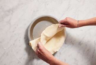 Beginning to fold rolled-out pie dough in half